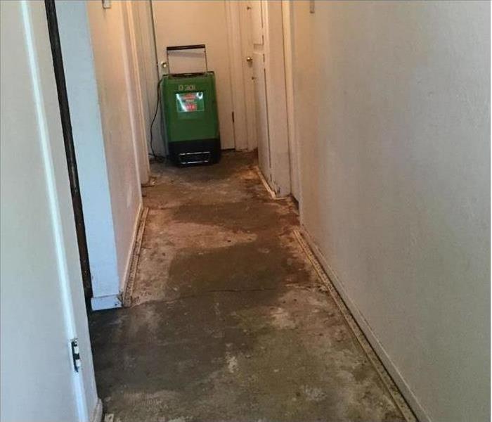 Same hallway showing no carpet and drying equipment placed