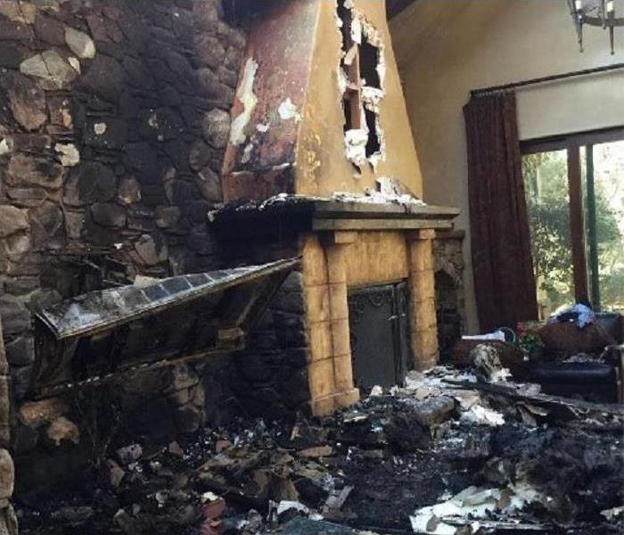 Fire place and living room devastated by fire damage with ash and soot everywhere