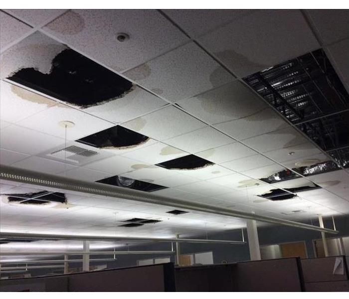 Business office ceiling with many panels fallen due to water damage